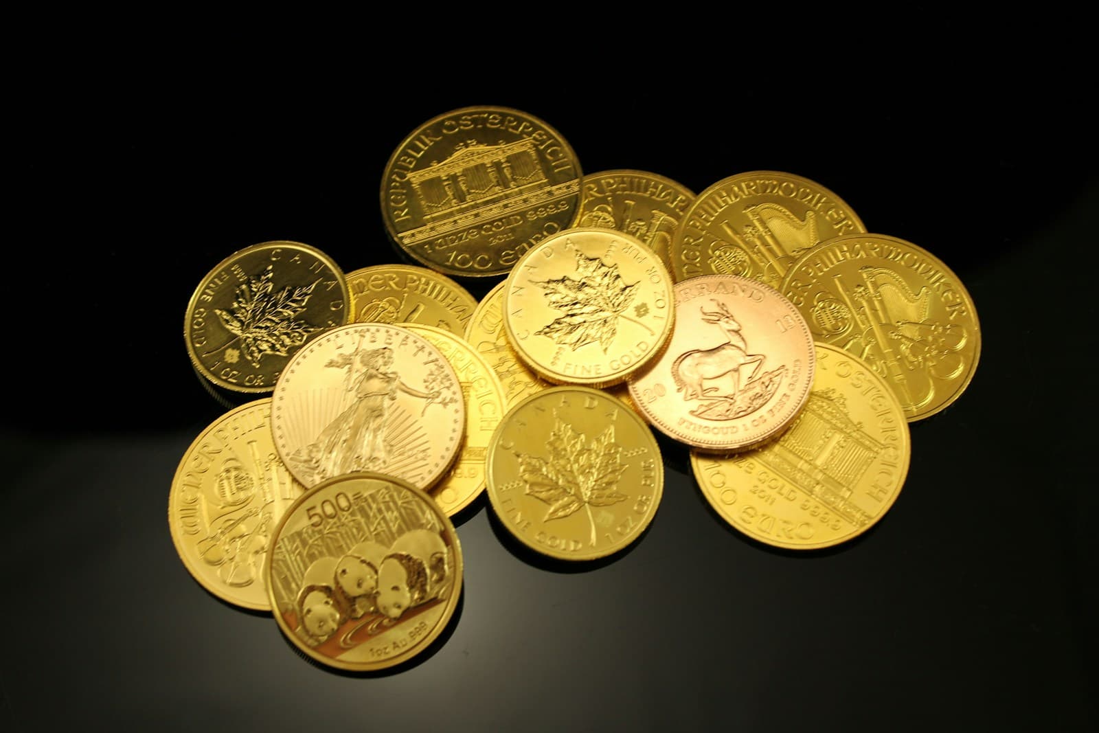 Pile of gold bullion coins — Eagles, Maple Leafs, Krugerrand
